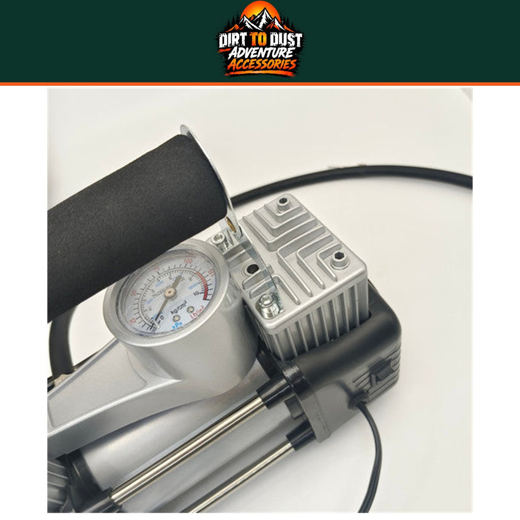 Close-up of the compressor analogue pressure gauge, hose and twin-cylinder housing.